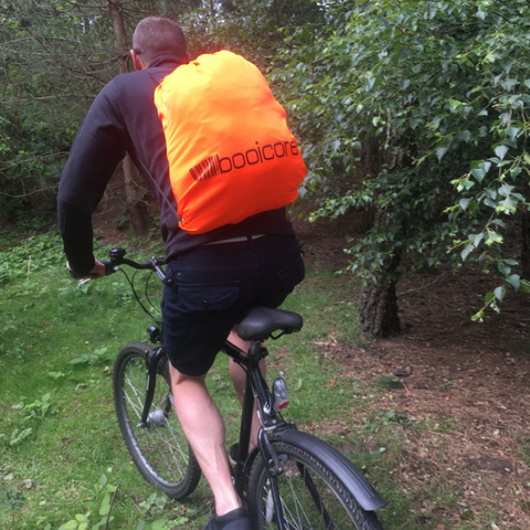 man on a mountain bike with the mtb essential gear kit bag from booicore on his back