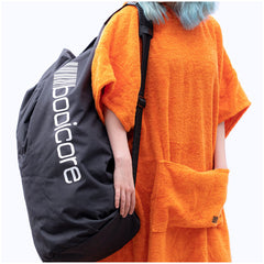 black booicore dirtbag bag over the shoulder of a open outdoor swimmer change dry robe